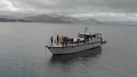 SLOWMO---People-fishing-off-anchored-cruise-boat-in-bay-in-Marlborough-Sounds,-New-Zealand