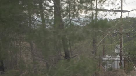 Electricity-pylon-cables-seen-from-car-tracking-shot-slow-motion