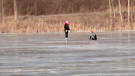 Two-young-children-are-playing-and-skating-on-ice