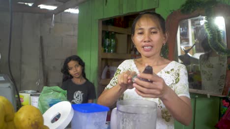 Lady-scraping-fresh-avocado-into-a-blender-to-be-mixed-into-a-delicious-fresh-fruit-drink-she-sells-from-her-roadside-stall