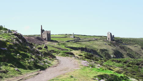 Tourist-walking-toward-the-Poldark-famous-tin-and-copper-mine-location-known-as-wheal-leisure