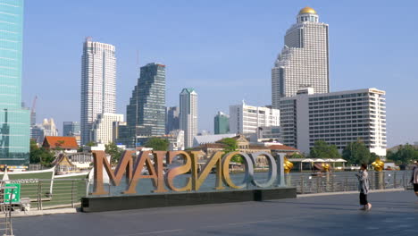 Icono-De-Señalización-De-Siam-Con-Vistas-Al-Horizonte-De-La-Ciudad-De-Bangkok-En-El-Fondo-Contra-El-Cielo-Azul