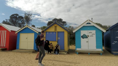 Touristen-Gehen-Und-Fotografieren-In-Brighton-Bathing-Boxes,-Melbourne,-Australien