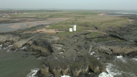 An-aerial-view-of-Elie-Ness-lighthouse-and-surrounding-coastline-on-a-misty-day,-Fife,-Scotland