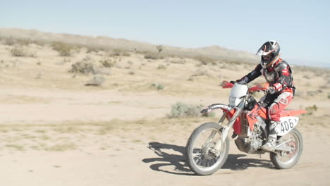 Zeitlupe:-Ein-Dirtbiker-Fährt-Mit-Seinem-Motorrad-Von-Rechts-Nach-Links-Durch-Die-Wüste