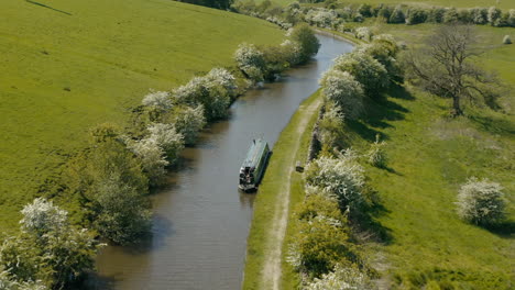 Una-Vista-Aérea-De-Un-Canal-Y-Un-Barco-De-Canal-Rodeado-Por-El-Campo-De-Yorkshire-En-Un-Soleado-Día-De-Primavera