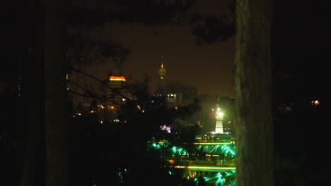 Nachtskyline-Von-Teheran-Mit-Dem-Milad-Turm,-Der-Durch-Bäume-Im-Ab-o-Atash-Park-In-Der-Hauptstadt-Der-Stadt-Zu-Sehen-Ist