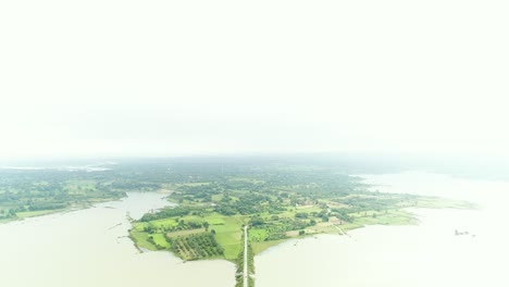 Rückwärtsfliegende-Luftaufnahme-Der-Landschaft-Mit-Einer-Brücke-über-Den-Fluss