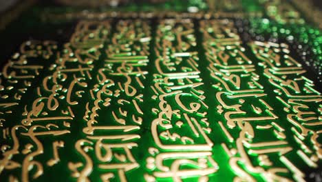Goldene-Arabische-Schrift-Auf-Dunkelgrünem-Plakat,-Dekoration,-Nahaufnahme,-Schieberegler,-Glaube,-Menschheit,-Kultur,-Beobachtung