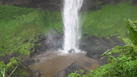 Eine-Aufnahme-Eines-Mächtigen-Wasserfalls,-Der-In-Einem-üppigen-Tropischen-Grünen-Tal-Auf-Den-Boden-Prasselt