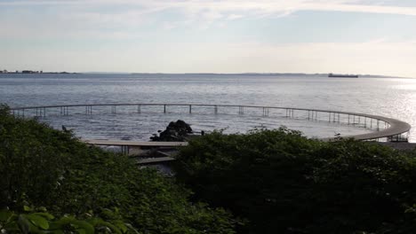 The-infinite-bridge-in-Aarhus,-Denmark-during-a-warm-summer-sunrise-on-the-beach