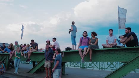 People-sitting-on-liberty-bridgein-szabihid-festival