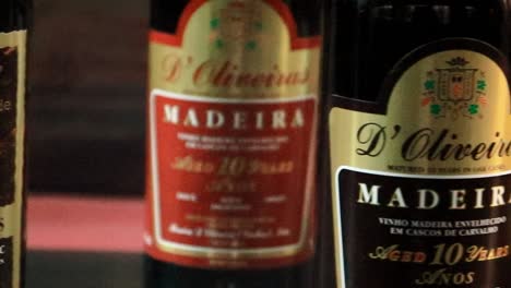 Madeira-Wein,-Feinste-Flaschensammlung,-Schwenk,-Freilegen-Von-Alten-Flaschen,-Regal,-Likörwein,-Portugiesischer-Archipel,-Toast,-Getränk-Der-Unterzeichnung-Der-Amerikanischen-Unabhängigkeitserklärung,-Exportrevolutionär