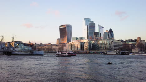 Citycruises-tour-boat-and-HMS-Belfast-ship-in-front-of-corporate-office-skyscrapers