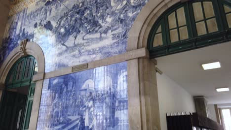 Tilt-up-to-view-iconic-azulejo-ceramic-tile-art-panels-in-Sao-Bento-Train-Station-in-Porto,-Portugal