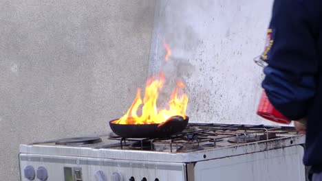 Feuerwehrmann-Entzündet-Fett-In-Pfanne-Auf-Herd