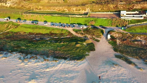 Praia-do-Norte-parking-lot-in-world-famous-record-large-wave-surfing-spot,-Aerial-drone-retreat-reveal-shot