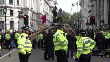 Während-Der-Extinction-Rebellion-Proteste-In-London,-Großbritannien,-Umzingelt-Die-Polizei-Eine-Proteststraßensperre