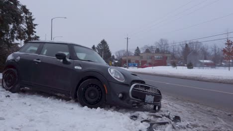 Small-vehicle-post-accident-at-side-of-road-during-winter