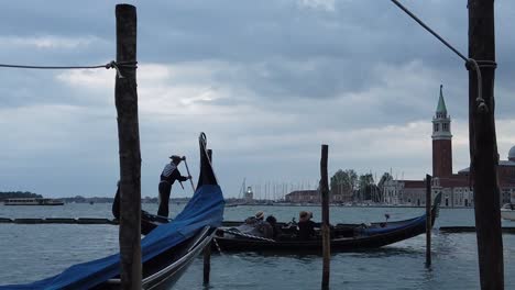 Turistas-En-Góndolas-Venecianas-Estacionados-En-El-Muelle-Del-Canal-De-Venecia