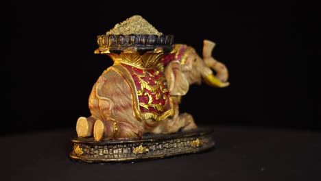 Pequeña-Escultura-De-Un-Elefante-Asiático-Sosteniendo-En-Su-Espalda-Especias-Aromáticas-Indias,-Vista-Giratoria-360-En-Pantalla-Negra