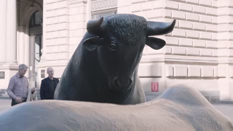 Static-shot-of-Bull-statue-with-bear-in-forefront-at-daylight,-Frankfurt,-Hessen,-Germany