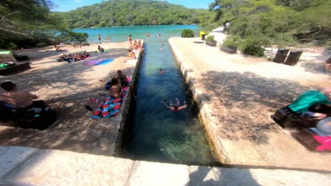People-having-fun-with-tidal-current-between-Malo-Jezero-and-Veliko-Jezero-on-the-Mljet-island,-Croatia