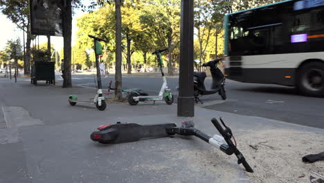 Elektroroller-Liegen-Auf-Dem-Bürgersteig-Und-Werden-In-Den-Straßen-Von-Paris-In-Der-Nähe-Der-Champs-Élysées-Verlegt