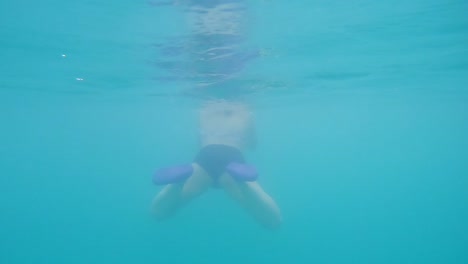 Mujer-Nadando-En-Agua-Clara-Entre-Las-Montañas-De-La-Isla-De-Koh-Phi-Phi,-Tailandia