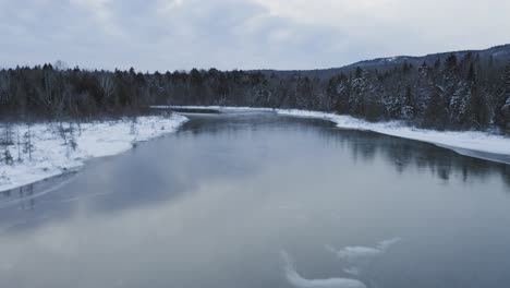 Aerial-flight-down-frozen-river-Winter-wonderland