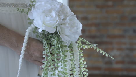 Bride-wearing-wedding-dress-holding-bouquet-of-flowers