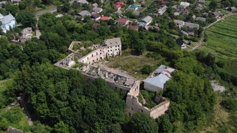 Aerial-View-of-Old-Abandoned-Building-Surrounded-by-Nature-Descending-Down