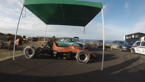 Nuevo-Coche-De-Carreras-Bajo-La-Carpa-Verde-En-La-Colina-En-Imtahleb-Malta-Con-Ruedas-Cubiertas-De-Plástico---Primer-Plano-De-Gopro