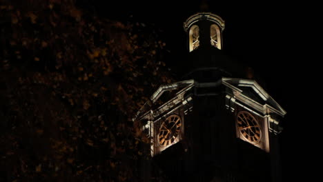 The-beautiful-clock-tower-of-the-Domkyrkan-church-in-central-Gothenburg,-Sweden-during-the-night---Tilt-up-slow-pan-shot