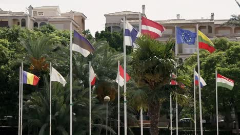 Flags-of-the-European-Nations-flying-in-a-park-in-Spain,-in-slow-motion