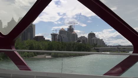 Construcción-Urbana-Desde-El-Tramo-Del-Puente-De-La-Paz-De-Calgary,-Scooter-Pasa