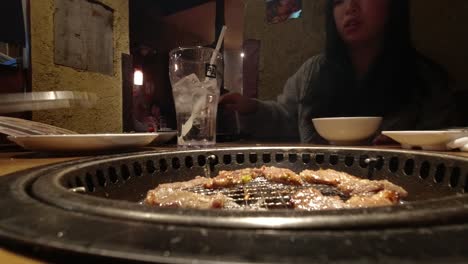 Hombre-Asando-Y-Sirviendo-Yakiniku-A-Una-Chica-Asiática-En-Un-Izakaya-En-Japón---Primer-Plano