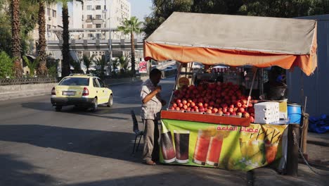 Vendedor-Masculino-De-Manzanas-Apilando-Sus-Frutas-En-La-Calle-Lateral