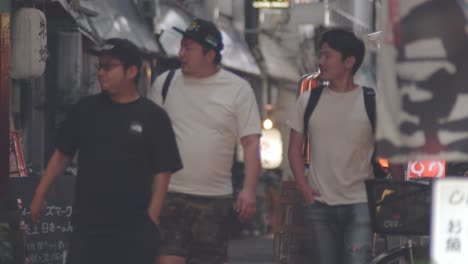 Group-Japanese-Walking-In-The-Street-And-Looking-Around-The-Restaurants-And-Pub-At-Night-In-Kamata,-Oto-City-In-Tokyo,-Japan