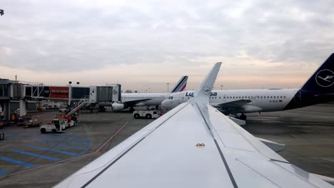 Wing-view-of-Lufthansa-airplane-taxiing-away-from-the-gate-at-the-Toulouse-airport-in-Blagnac,-France