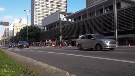 Vehículos-Y-Ciclistas-Compartiendo-Espacio-En-La-Avenida-Paulista,-La-Más-Famosa-De-La-Ciudad