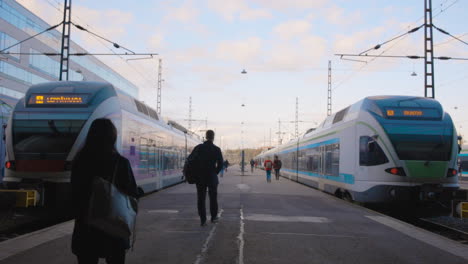 Umrissene-Passagiere-Gehen-Auf-Einem-Bahnsteig-Auf-Die-Züge-Zu