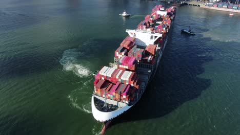 Zwei-Schlepper-Manövrieren-Ein-Großes-Leeres-Containerschiff-In-Den-Hafen-Von-Hongkong,-Luftbild