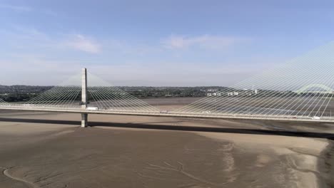 Vehicles-crossing-over-landmark-river-Mersey-gateway-bridge-aerial-view-dolly-left