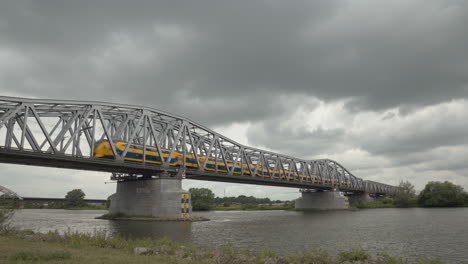 Ein-Niederländischer-Intercity-Zug-Und-Ein-Güterzug-Fahren-über-Die-Brücke-Bei-Hedel