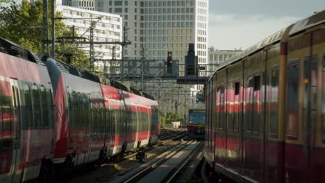 Öffentliche-Verkehrsmittel-Mit-Verschiedenen-Zügen-In-Berlin-Bei-Sonnenuntergang