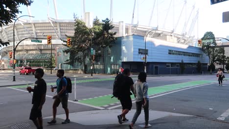 Menschen-überqueren-Die-Straße-Vor-Einem-Stadion-In-Vancouver,-Kanada