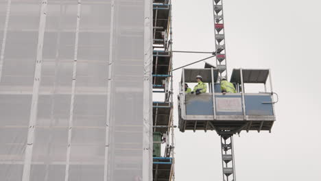 Constructores-Masculinos-En-Un-Ascensor-De-Construcción,-Cámara-Lenta