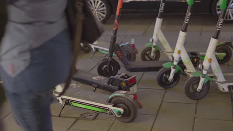 Rental-electric-scooters-laying-around-on-a-busy-sidewalk-in-Hamburg,-Germany