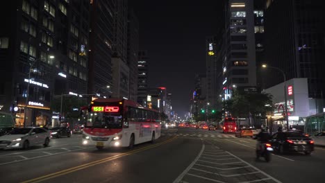 Autobuses-Que-Viajan-Por-La-Carretera-En-El-Distrito-De-Gangnam,-Seúl,-Corea-Del-Sur-Por-La-Noche---Plano-Amplio